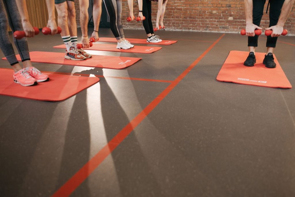 An indoor exercise group using dumbbells on mats